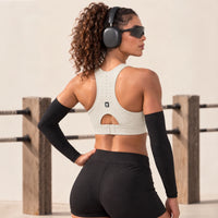 Top deportivo ASTRA de VALTIK en color Nácar, vista posterior en modelo con espalda perforada y cierre ajustable.