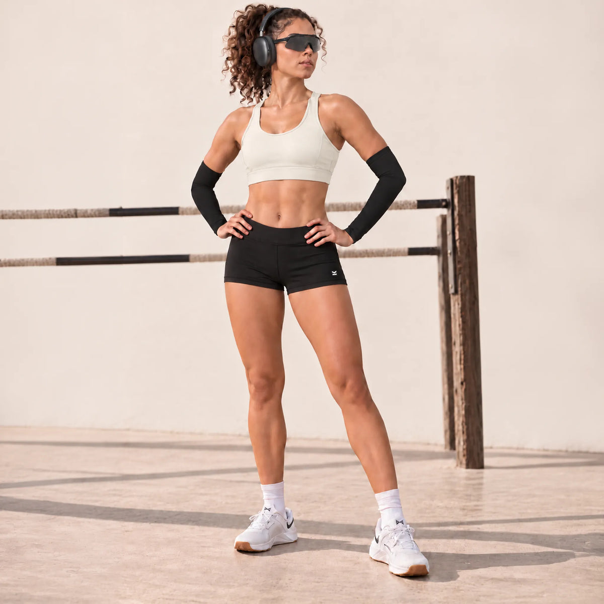 Top deportivo ASTRA de VALTIK en color Nácar, vista frontal en modelo de cuerpo completo con las manos en la cintura.