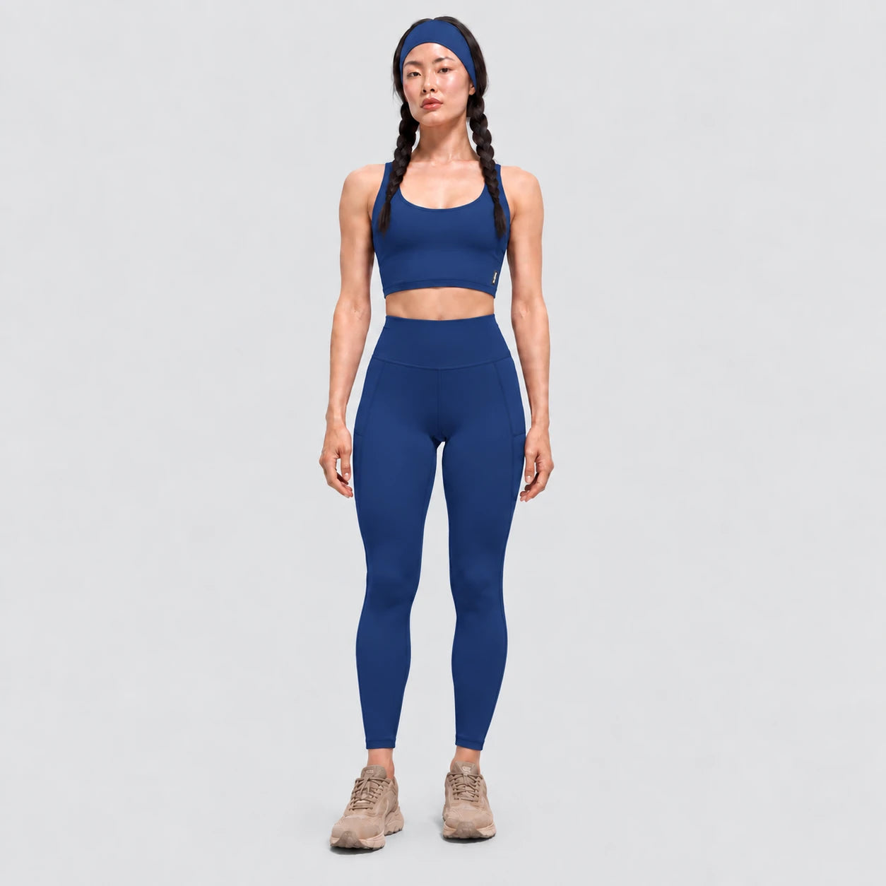 Top deportivo AURA de VALTIK para mujer en azul petróleo, vista frontal en modelo.