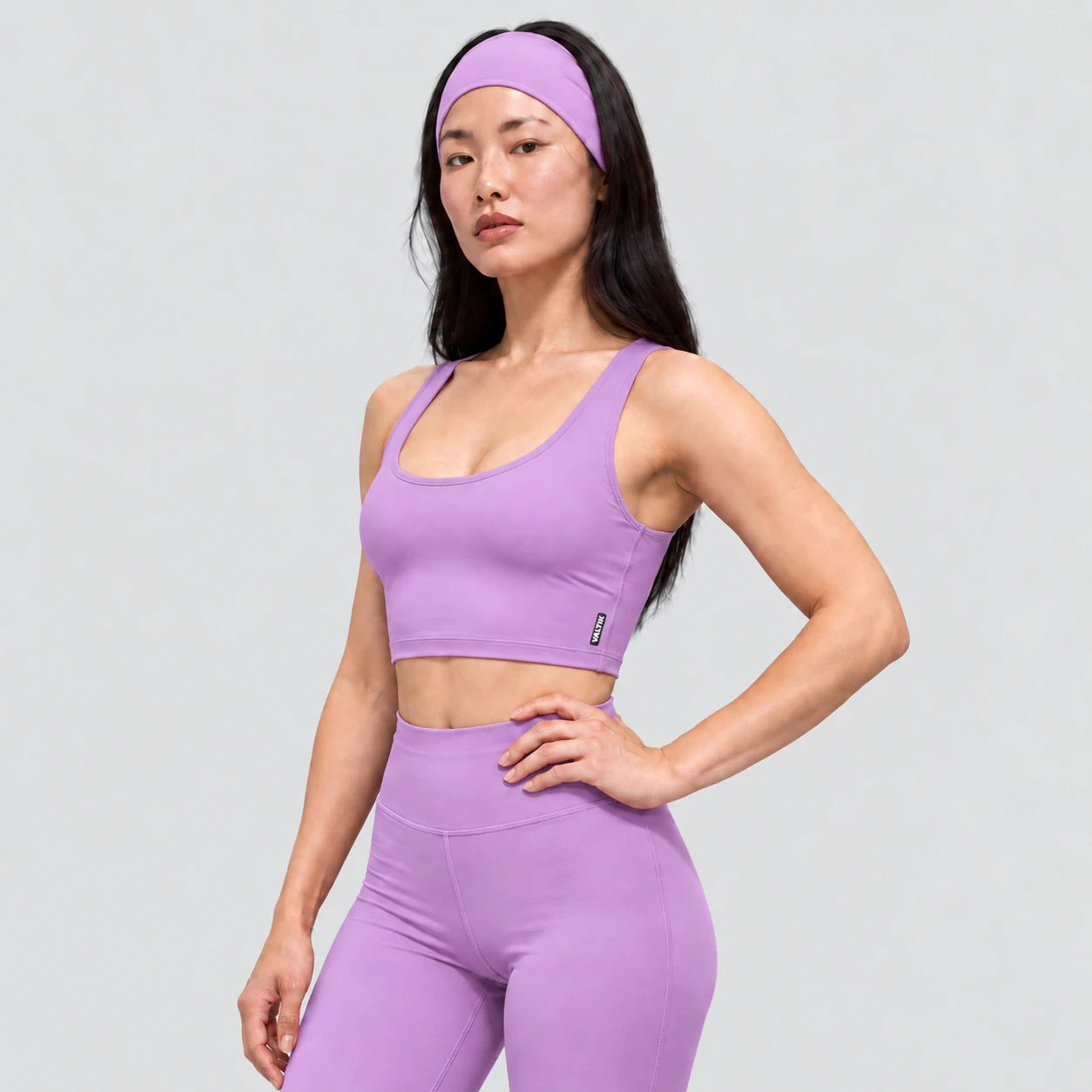 Top deportivo AURA de VALTIK para mujer en lila, vista de tres cuartos en modelo.