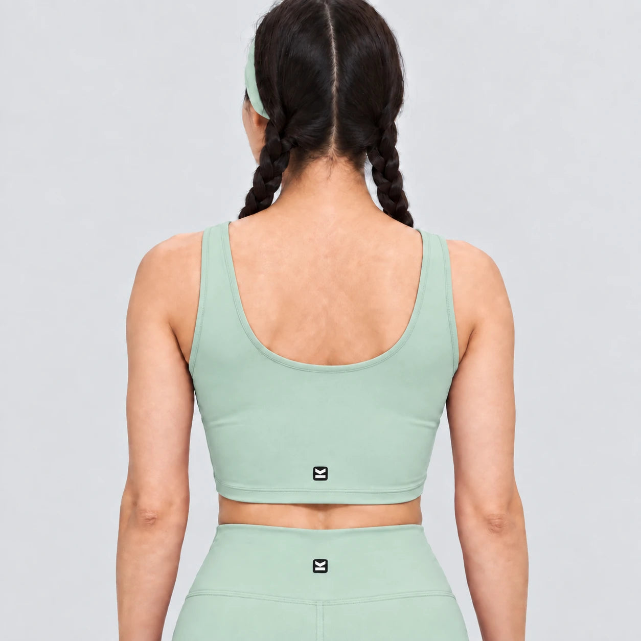 Top deportivo AURA de VALTIK para mujer en menta, vista de espalda en modelo.