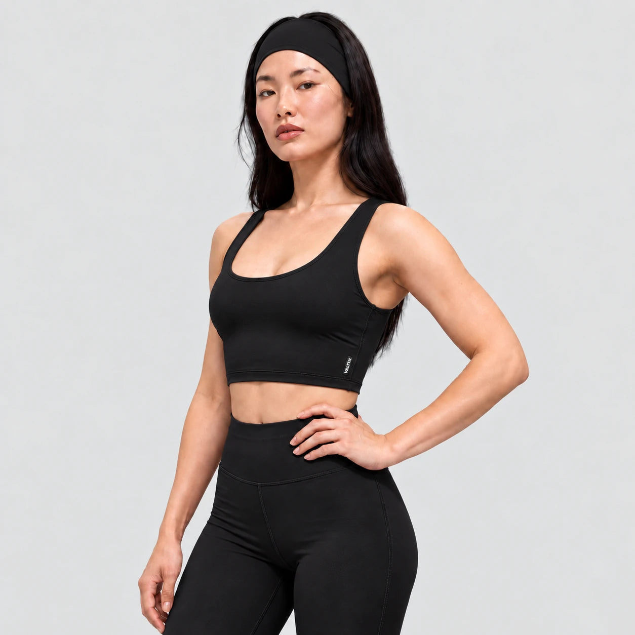 Top deportivo AURA de VALTIK para mujer en negro, vista de tres cuartos en modelo.