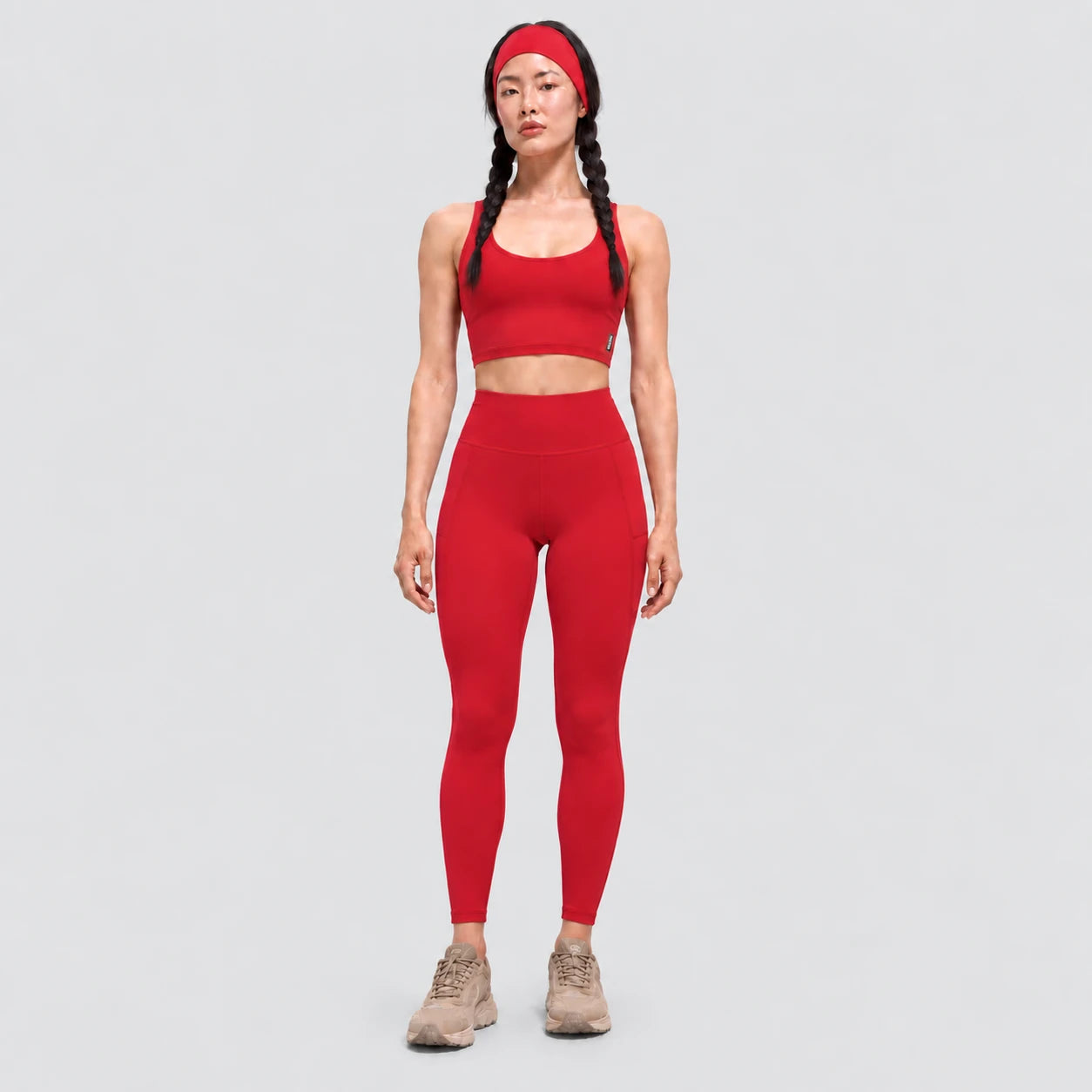 Top deportivo AURA de VALTIK para mujer en rojo, vista frontal en modelo.