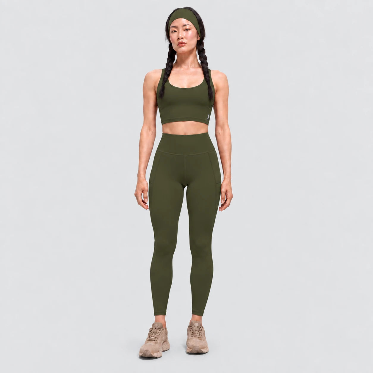 Top deportivo AURA de VALTIK para mujer en verde olivo, vista frontal en modelo.