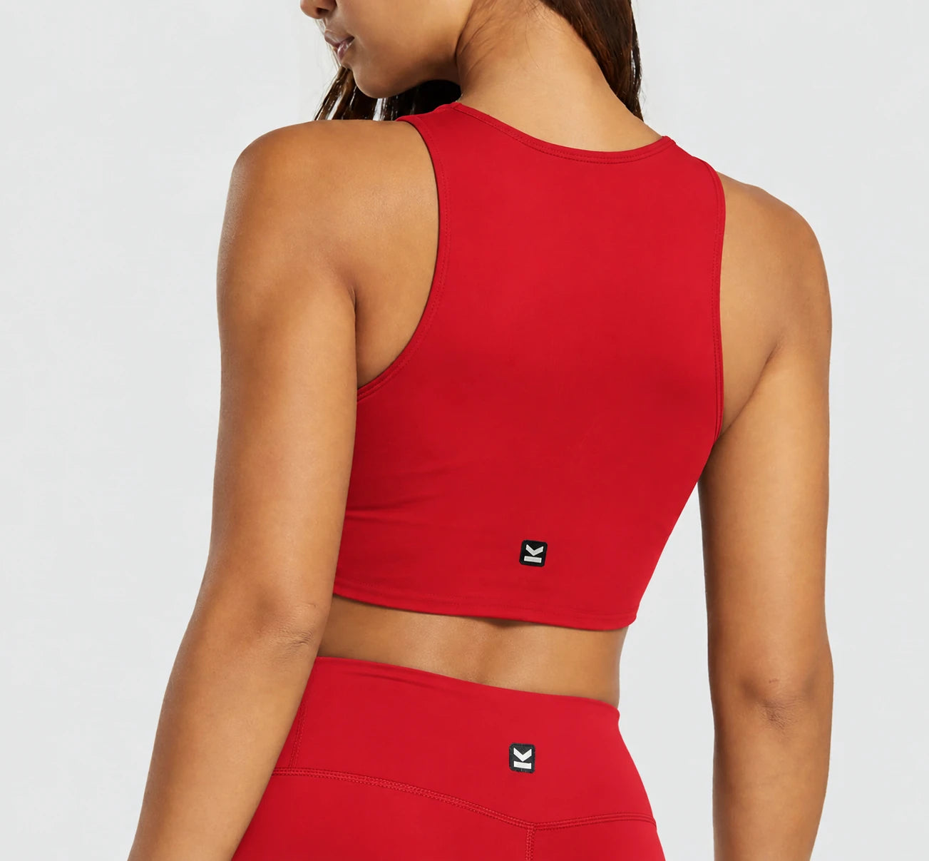 Top deportivo NOVA de VALTIK para mujer en rojo, vista de espalda en modelo.