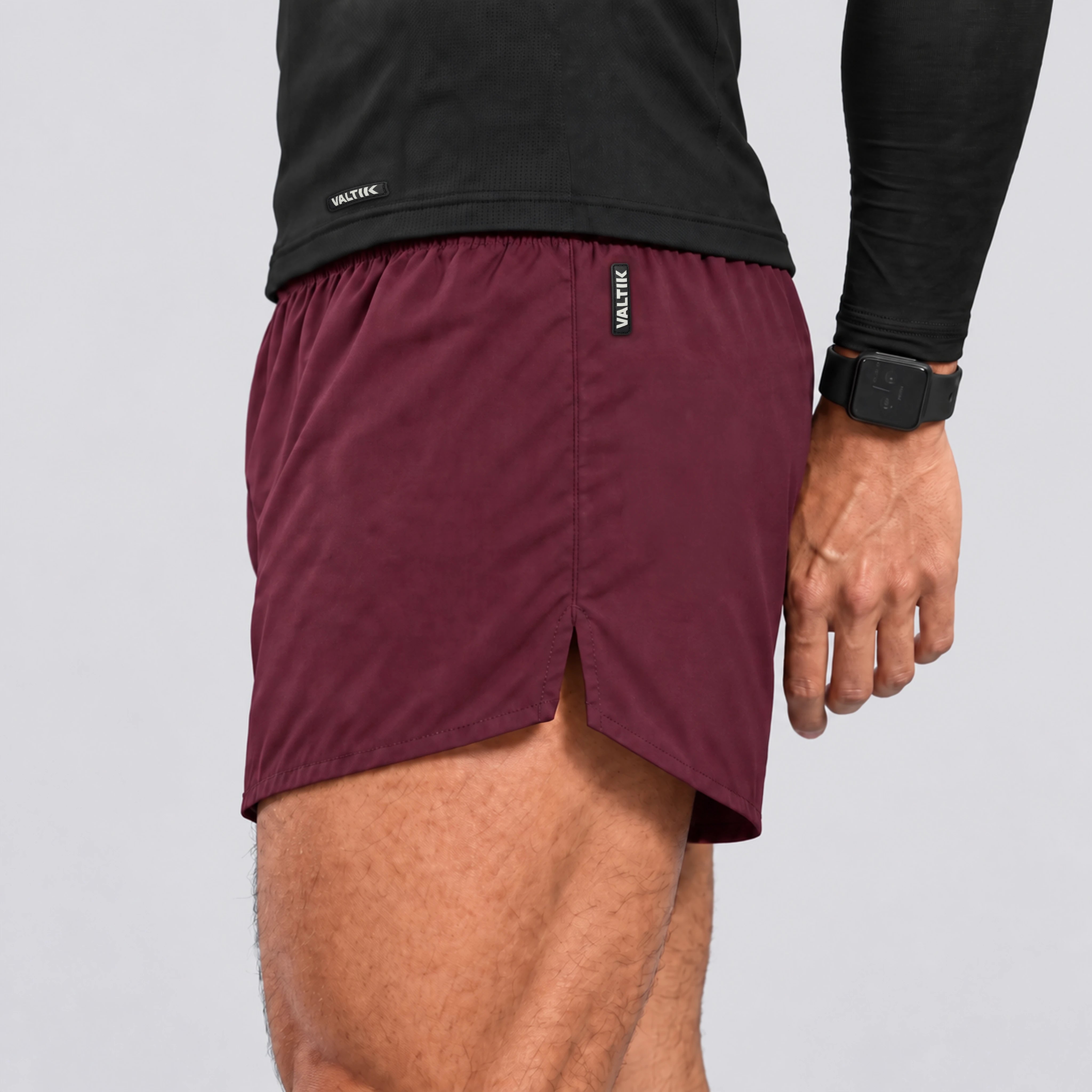 Short deportivo STRIDE de VALTIK para hombre en color guinda, detalle lateral de la abertura, costuras y etiqueta.