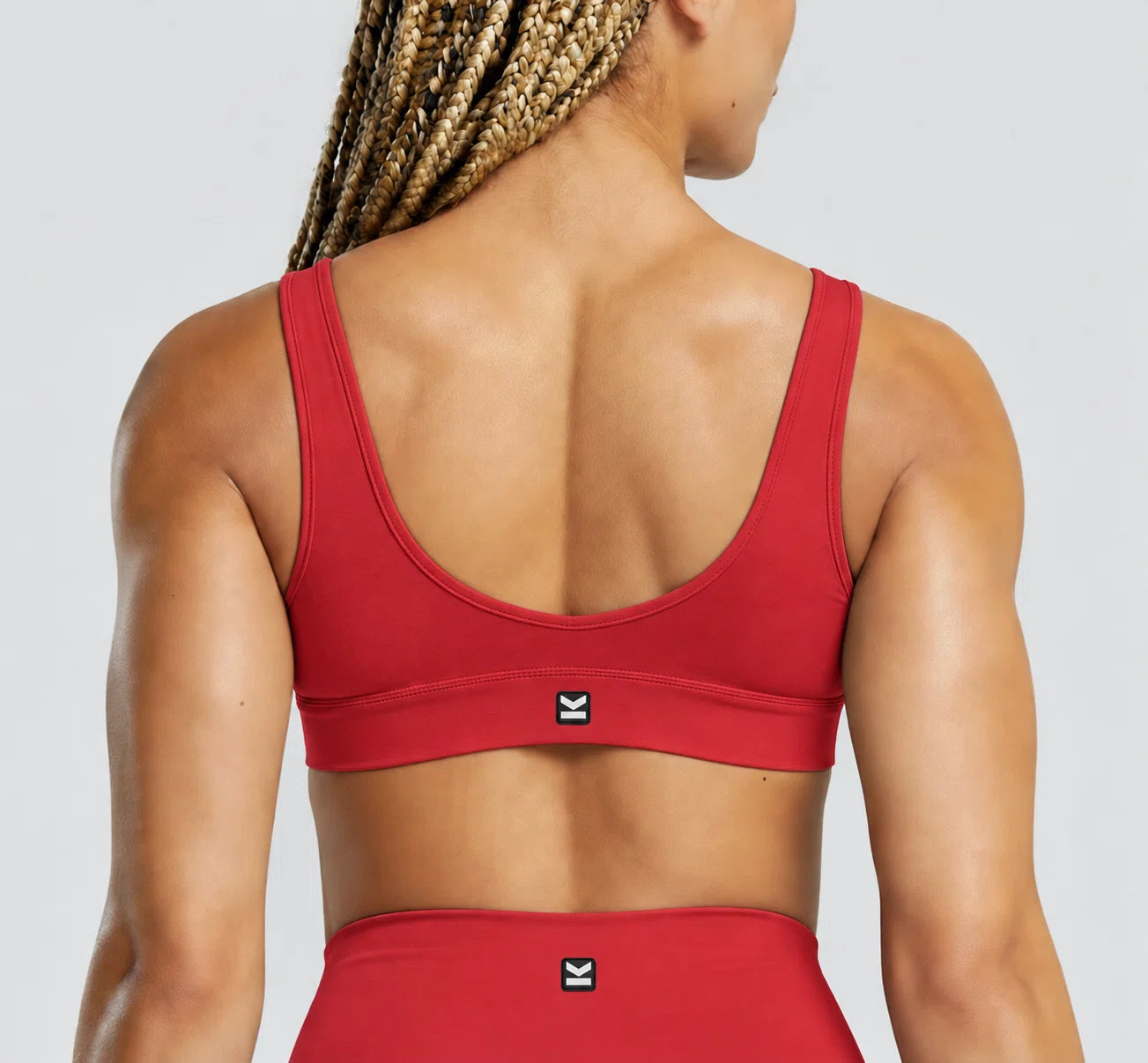 Top deportivo VEGA de VALTIK para mujer en rojo, vista de espalda en modelo.
